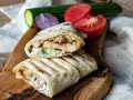 Pyszny domowy kebab w tortilli z kurczakiem, warzywami i sosem. Idealny na szybki obiad.