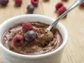 Aksamitny mus czekoladowy z mascarpone, ozdobiony malinami i borówką, gotowy do zjedzenia.