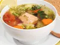 Aromatyczna zupa rybna przepis babci z łososiem, pomidorami, marchewką i ziemniakami, ozdobiona cytryną i natką.