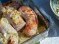 Biała kiełbasa pieczona z cebulką i musztardą w szklanym naczyniu. Apetyczny zapach unosi się w powietrzu.