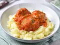 Pyszne pulpeciki w sosie pomidorowym na kremowym purée ziemniaczanym, posypane świeżym koperkiem.