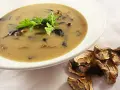 Aksamitna zupa grzybowa z suszonych grzybów, udekorowana natką pietruszki, obok suszone borowiki.