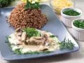Schab duszony z pieczarkami w kremowym sosie, podany z kaszą gryczaną i świeżymi ziołami. Pyszne danie obiadowe.