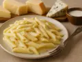 Penne w kremowym sosie serowym, z kawałkami parmezanu i sera pleśniowego w tle. Idealne danie mac and cheese.