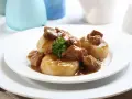 Kluski śląskie z gęstym, aromatycznym sosem mięsnym i gałązką natki pietruszki. Pyszny sos do kluski śląskie.