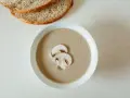 Kremowa zupa pieczarkowa z pieczywem. Jakie przyprawy do zupy pieczarkowej? Sól, pieprz, gałka muszkatołowa i tymianek podkreślą jej smak.