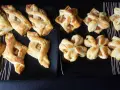 Słodkie przekąski z ciasta francuskiego z jabłkami, posypane cukrem. Różne kształty, niektóre przypominają gwiazdki.