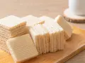 Chrupiące wafle z mlekiem w proszku i galaretką, ułożone na drewnianej desce. Idealne na deser.