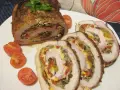 Pyszna rolada schabowa z pieczarkami i warzywami, pokrojona w plastry, podana z pomidorkami koktajlowymi.