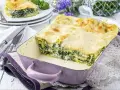 Pyszne lasagne ze szpinakiem i beszamelem, zapieczone na złoto, w fioletowym naczyniu. Idealna na rodzinny obiad.
