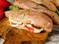 Nadziewana pierś z kurczaka z mozzarellą i suszonymi pomidorami, przyprawiona ziołami, gotowa do pieczenia.