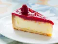 Pyszny sernik na zimno z sera z wiaderka i galaretek, zwieńczony maliną. Idealny deser na letnie popołudnie.