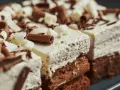 Puszysty krem cappuccino do tortu, udekorowany czekoladowymi wiórkami i białymi spiralkami. Idealny na deser.