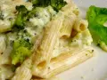 Penne z brokułami w kremowym sosie serowym, udekorowane listkiem bazylii. Pyszne danie, które zachwyci każdego smakosza.