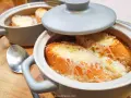 Gorąca zupa cebulowa z grzankami, zapieczona pod serem. Idealna na chłodne dni.