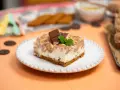 Pyszny deser Kinder Country na kruchym spodzie, polany czekoladą i posypany orzeszkami. Idealny na każdą okazję!