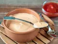 Kremowy sos do gyrosa na łyżeczce, obok miseczka z ketchupem. Idealny dodatek do ulubionego dania.
