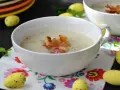 Aksamitna zupa krem chrzanowa z chrupiącymi grzankami i boczkiem, ozdobiona wielkanocnymi jajeczkami.