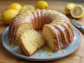 Wilgotna babka cytrynowa na oleju, polana lukrem i posypana skórką cytrynową, prezentuje się apetycznie na talerzu.