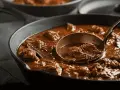 Gulasz w żeliwnej patelni, nabierany chochlą. Idealny przykład, jak zredukować sos, by był gęstszy i bardziej aromatyczny.