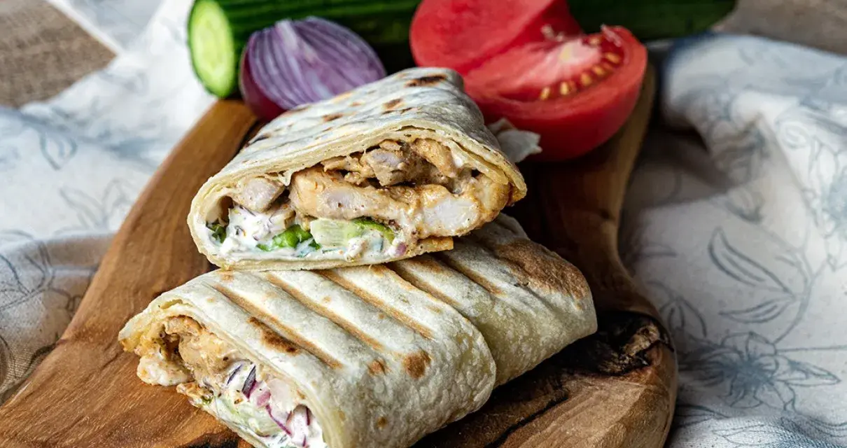 Pyszny domowy kebab w tortilli z kurczakiem, warzywami i sosem. Idealny na szybki obiad.