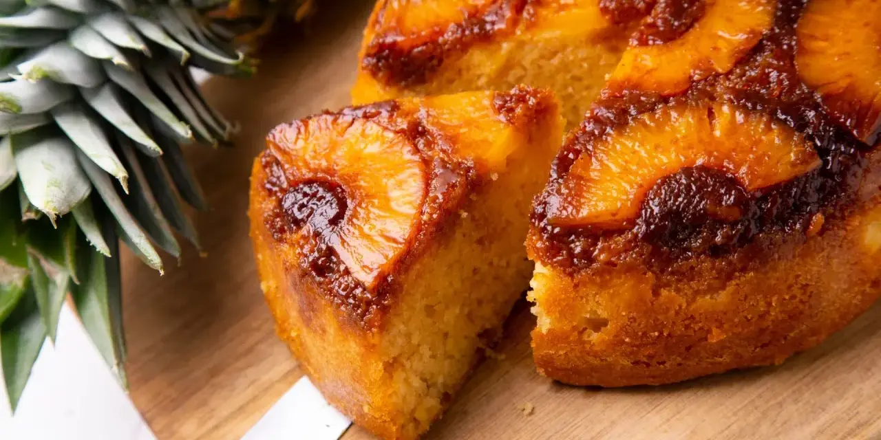 Pyszne ciasto z patelni z ananasem i karmelizowaną skórką, obok świeży ananas.