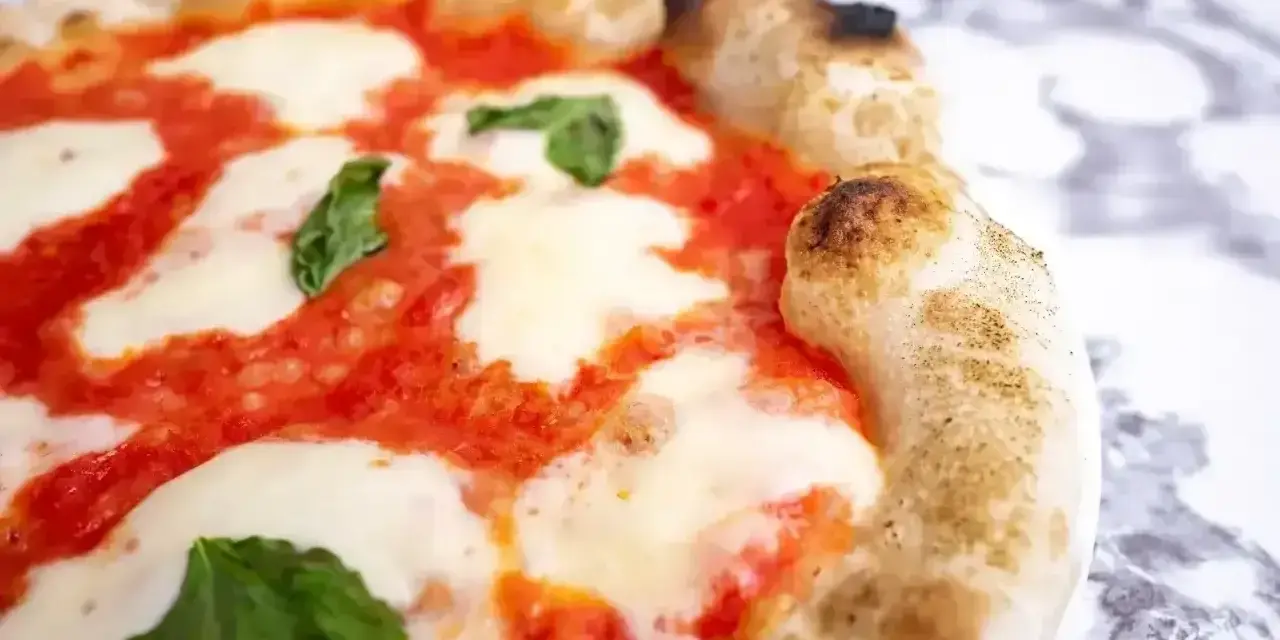 Puszyste ciasto na pizzę z sosem pomidorowym, ciągnącą się mozzarellą i listkami bazylii. Idealne na wieczór z przyjaciółmi.