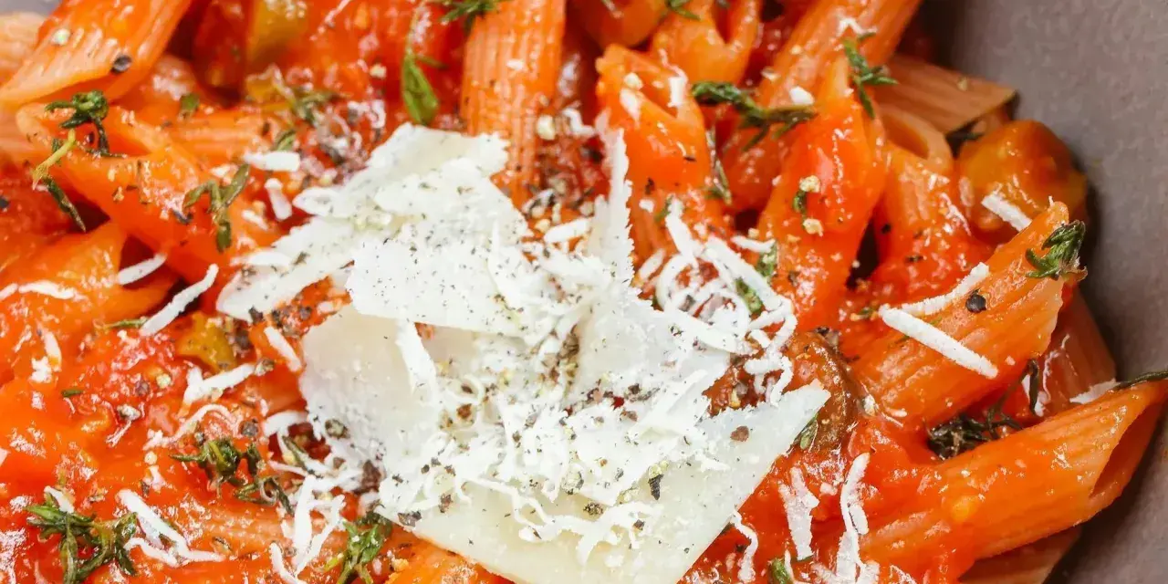 Pyszne dania z makaronem penne w sosie pomidorowym z parmezanem i ziołami. Idealne na szybki obiad.