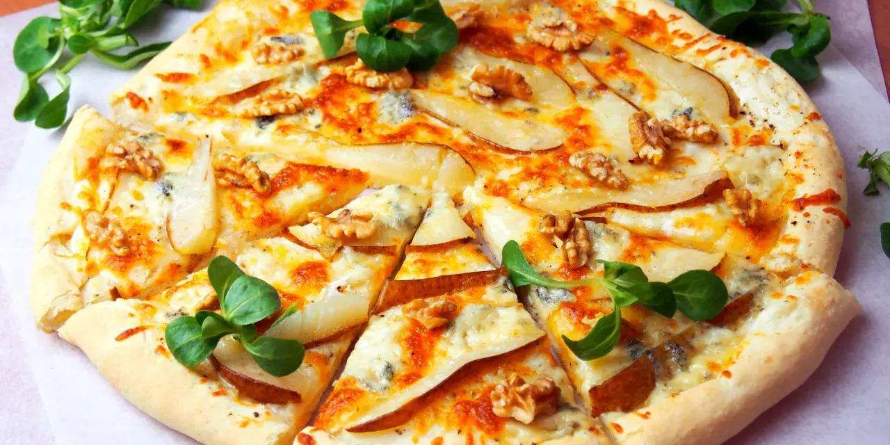 Apetyczna pizza z gruszką i gorgonzolą, ozdobiona orzechami włoskimi i świeżą rukolą. Idealna na wyjątkowy wieczór.