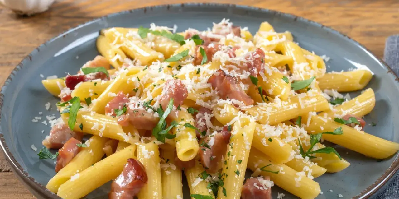 Penne rigate z boczkiem i parmezanem, posypane świeżą natką pietruszki. Pyszne spaghetti z serem, które zachwyca smakiem.