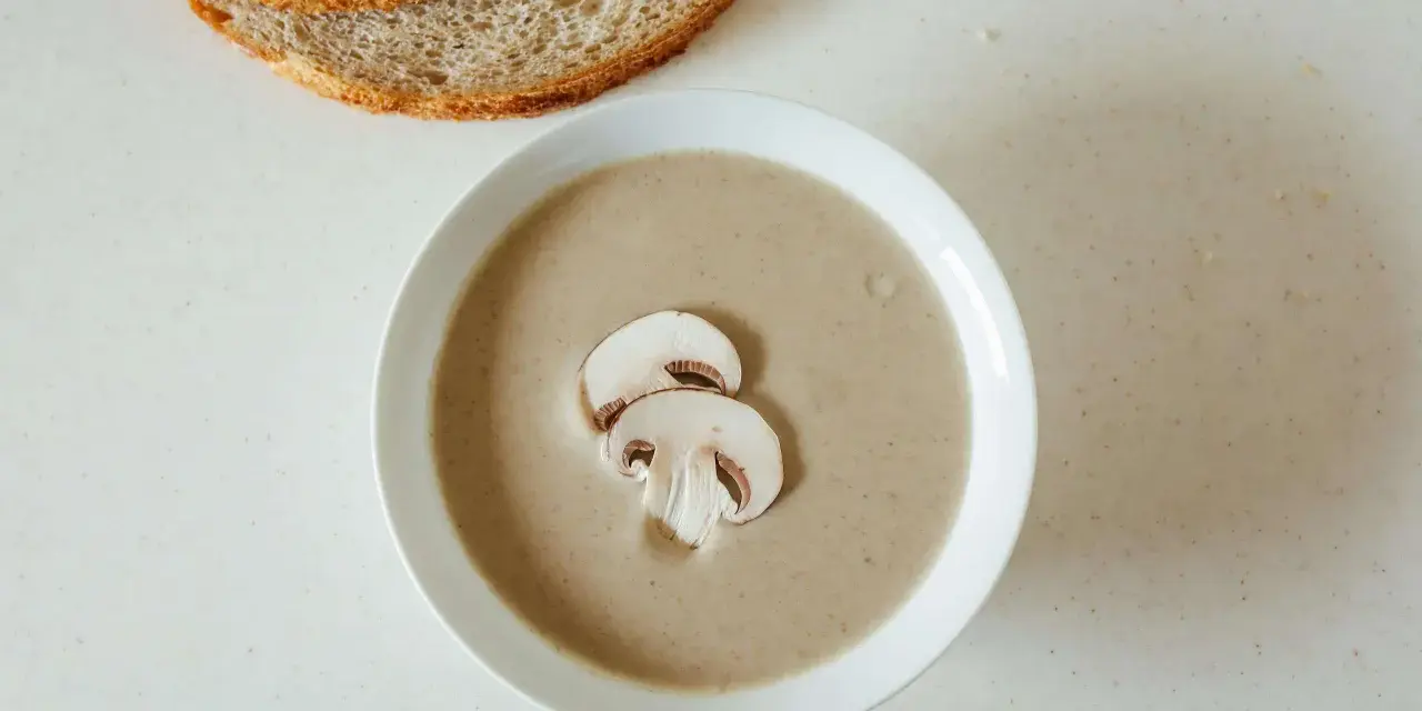 Kremowa zupa pieczarkowa z pieczywem. Jakie przyprawy do zupy pieczarkowej? Sól, pieprz, gałka muszkatołowa i tymianek podkreślą jej smak.