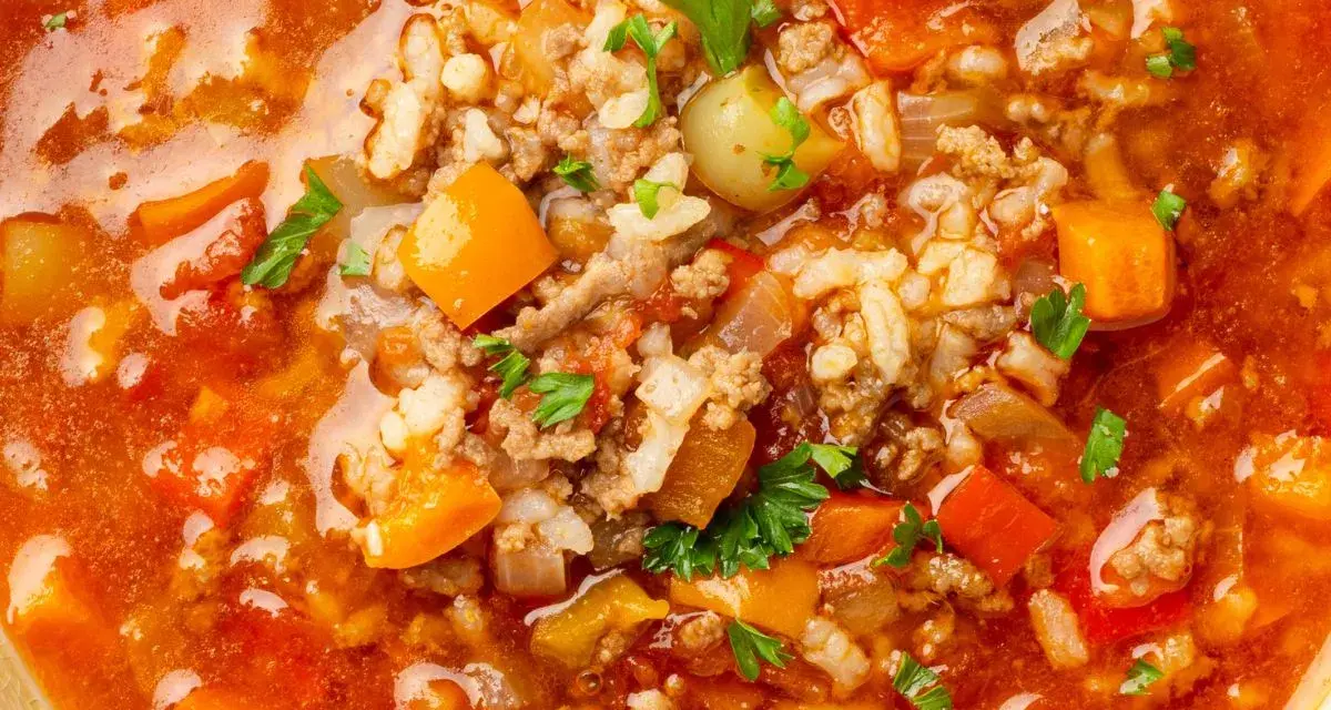 Gęsta, aromatyczna zupa z mięsem mielonym, ryżem, marchewką i papryką, posypana natką pietruszki.