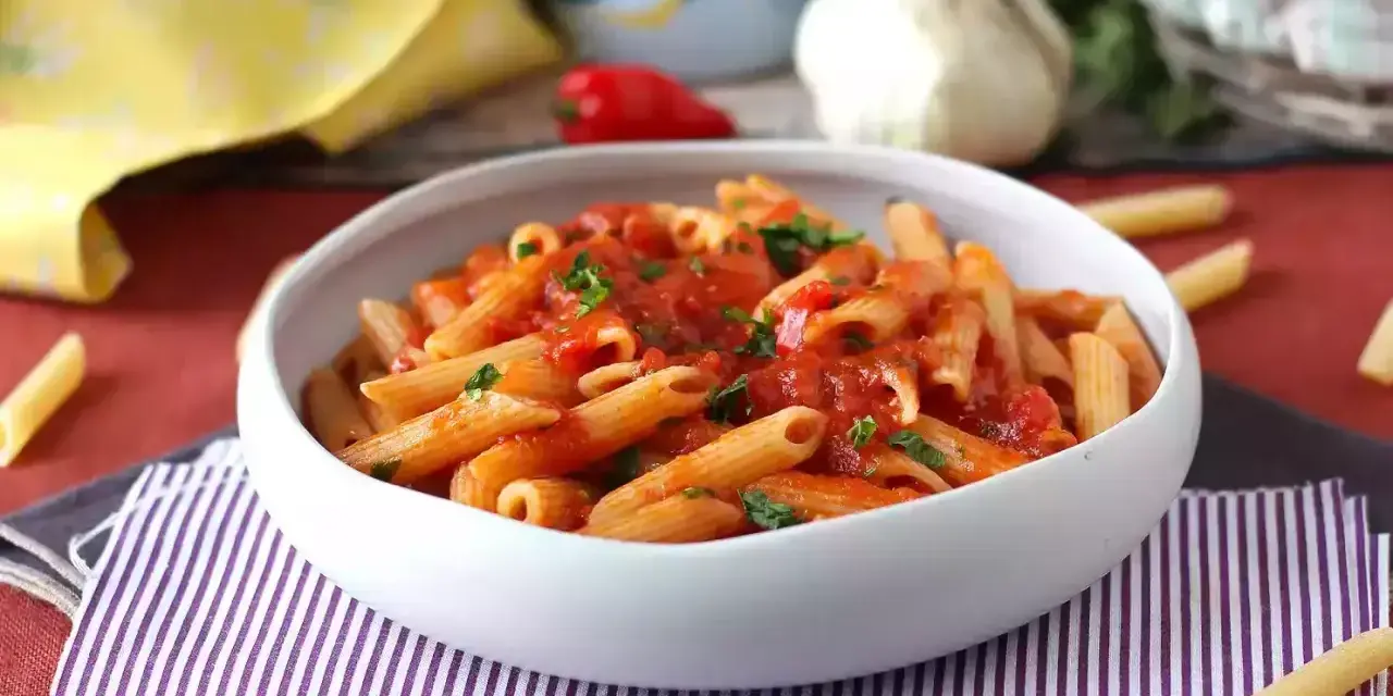 Penne w sosie pomidorowym, posypane natką pietruszki. Pyszny makaron z cukrem, który zachwyci każdego.