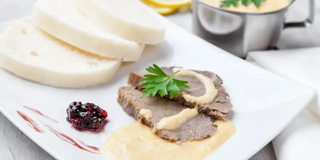 Plasterki pieczonego schabu z sosem, knedliki, konfitura z owoców leśnych i sos do schabu pieczonego w sosjerce.