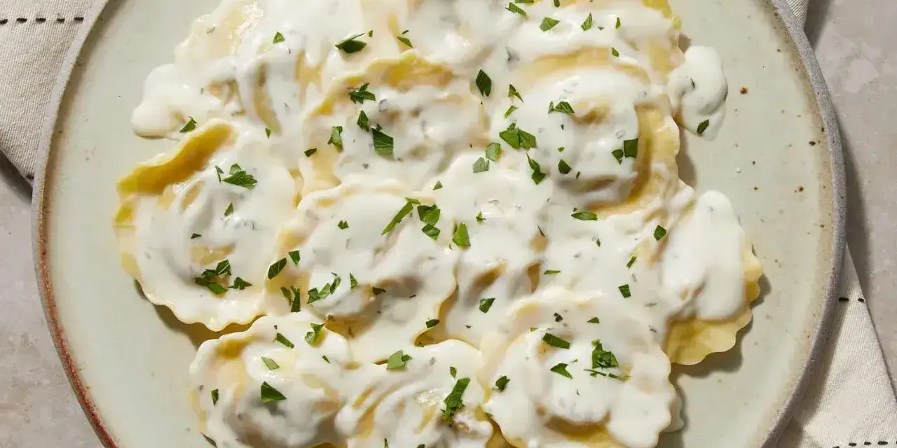 Ravioli w kremowym sosie, posypane natką pietruszki. Pyszny sos do ravioli, który zachwyca smakiem.