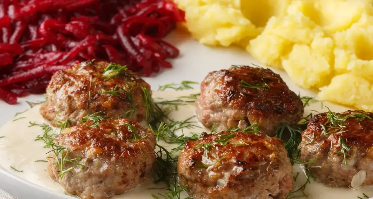 Pyszne klopsy w sosie, podane z puree ziemniaczanym i buraczkami. Idealny przepis na obiad!