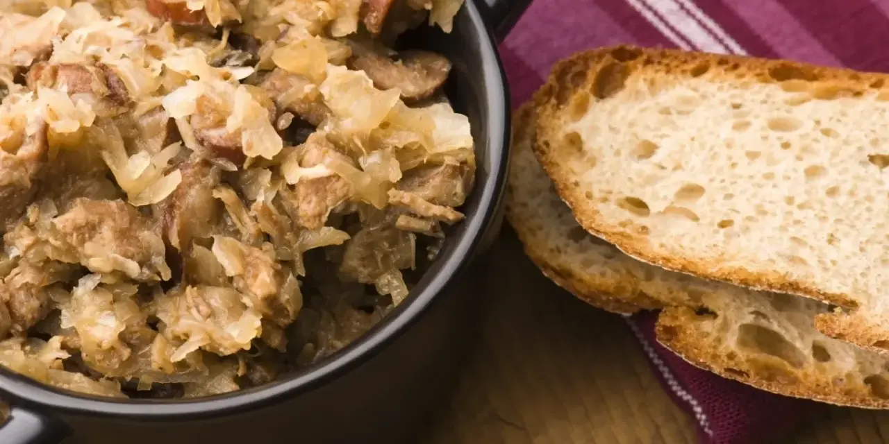 Pyszny bigos z różnymi rodzajami mięsa, podany z chrupiącym chlebem. Idealny wybór, jeśli zastanawiasz się, jakie mięso do bigosu wybrać.