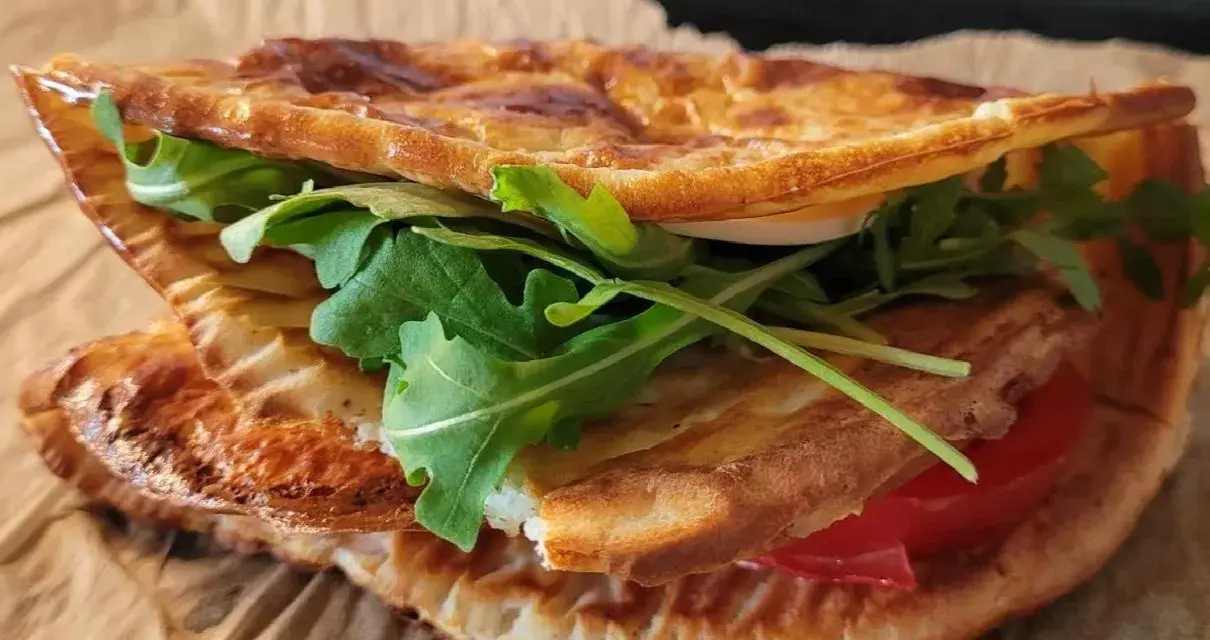 Pyszna tortilla z serka wiejskiego z rukolą i pomidorem, idealna na szybki lunch.