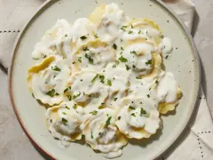 Ravioli w kremowym sosie, posypane natką pietruszki. Pyszny sos do ravioli, który zachwyca smakiem.