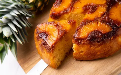 Pyszne ciasto z patelni z ananasem i karmelizowaną skórką, obok świeży ananas.