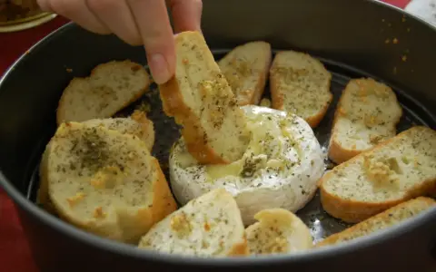 Ciepły, rozpływający się camembert z piekarnika, zanurzany w nim chrupiący grzaniec z ziołami. Idealna przekąska.