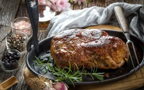 Soczysta karkówka z piekarnika, pieczona z rozmarynem i czosnkiem, podana w żeliwnej patelni.