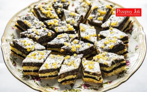 Pyszne ciastka z makiem, udekorowane lukrem i kandyzowaną skórką pomarańczową, ułożone na ozdobnej paterze.