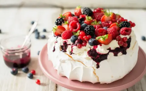 Pyszny deser Pavlova z owocami leśnymi – idealny sposób, by wykorzystać co zrobić z białek. Kremowa beza, bita śmietana i świeże owoce.