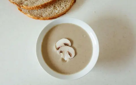 Kremowa zupa pieczarkowa z pieczywem. Jakie przyprawy do zupy pieczarkowej? Sól, pieprz, gałka muszkatołowa i tymianek podkreślą jej smak.