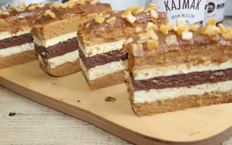 Pyszne ciasto toffi z masą kajmakową, przełożone czekoladowym biszkoptem i kremem. Udekorowane kandyzowanymi skórkami.