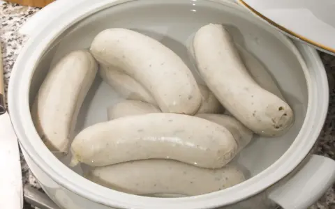 Biała kiełbasa w garnku, gotowa do przygotowania według przepisu.