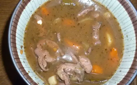 Gęsty, aromatyczny gulasz z serc indyczych z marchewką i ziemniakami w misce.