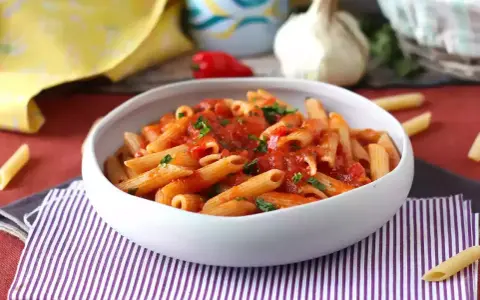 Penne w sosie pomidorowym, posypane natką pietruszki. Pyszny makaron z cukrem, który zachwyci każdego.