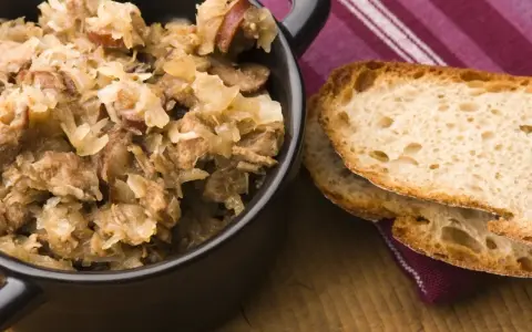 Pyszny bigos z różnymi rodzajami mięsa, podany z chrupiącym chlebem. Idealny wybór, jeśli zastanawiasz się, jakie mięso do bigosu wybrać.